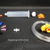 Dispense kit with nozzles, syringe, plunger (piston), back and front caps for the syringe and syringe adapter with pipe for Slurp'nPick+ and Pick+ stations